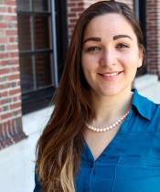 Photo of Courtney Berger Levinson, standing in front of a brick building.