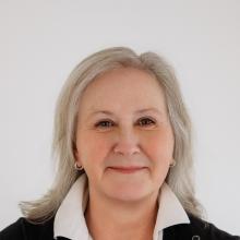 photo of woman wearing white shirt and black cardigan